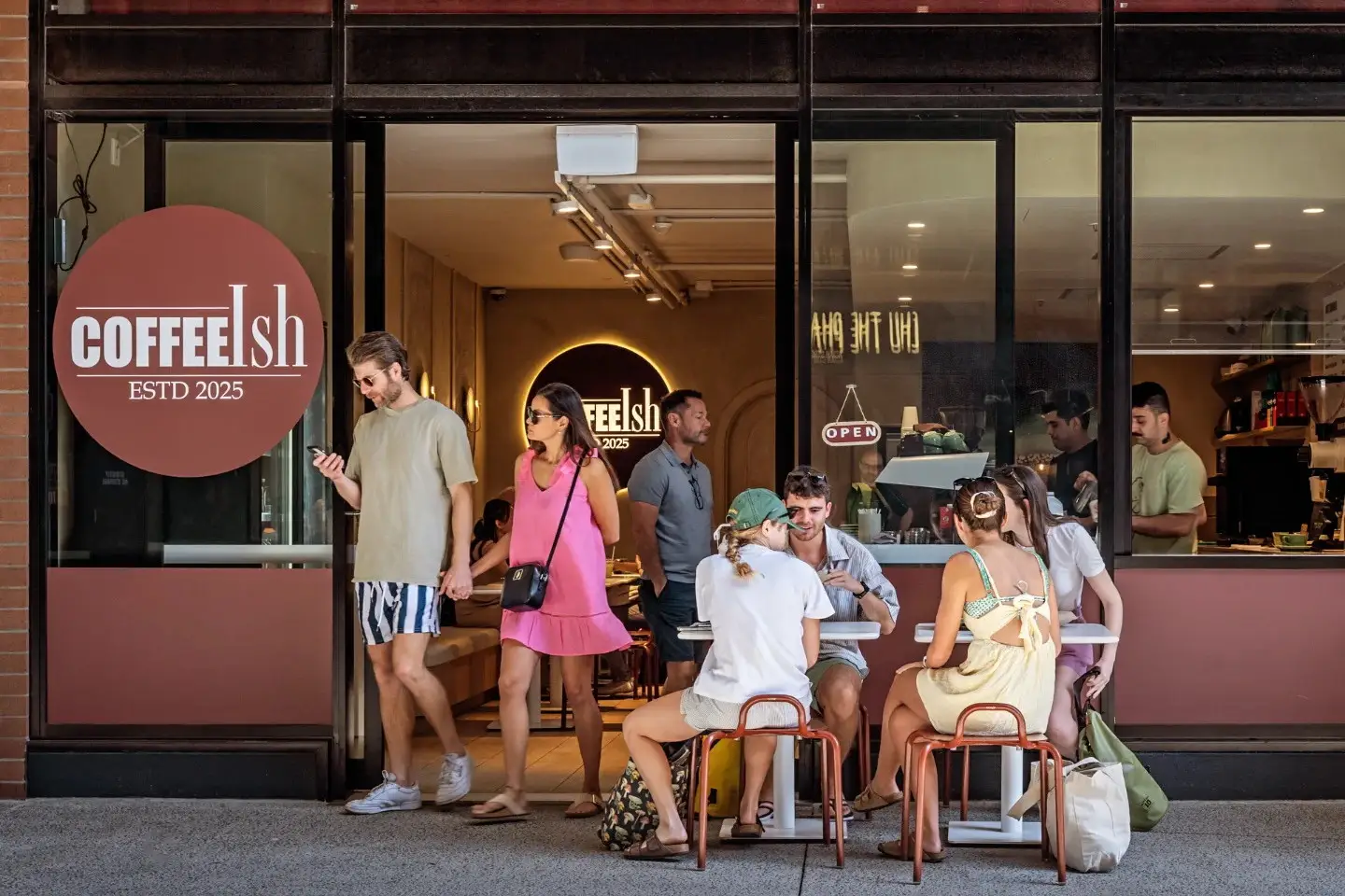The CoffeeIsh shopfront on Fish Lane, customers at the window tables and the lit sign inside.